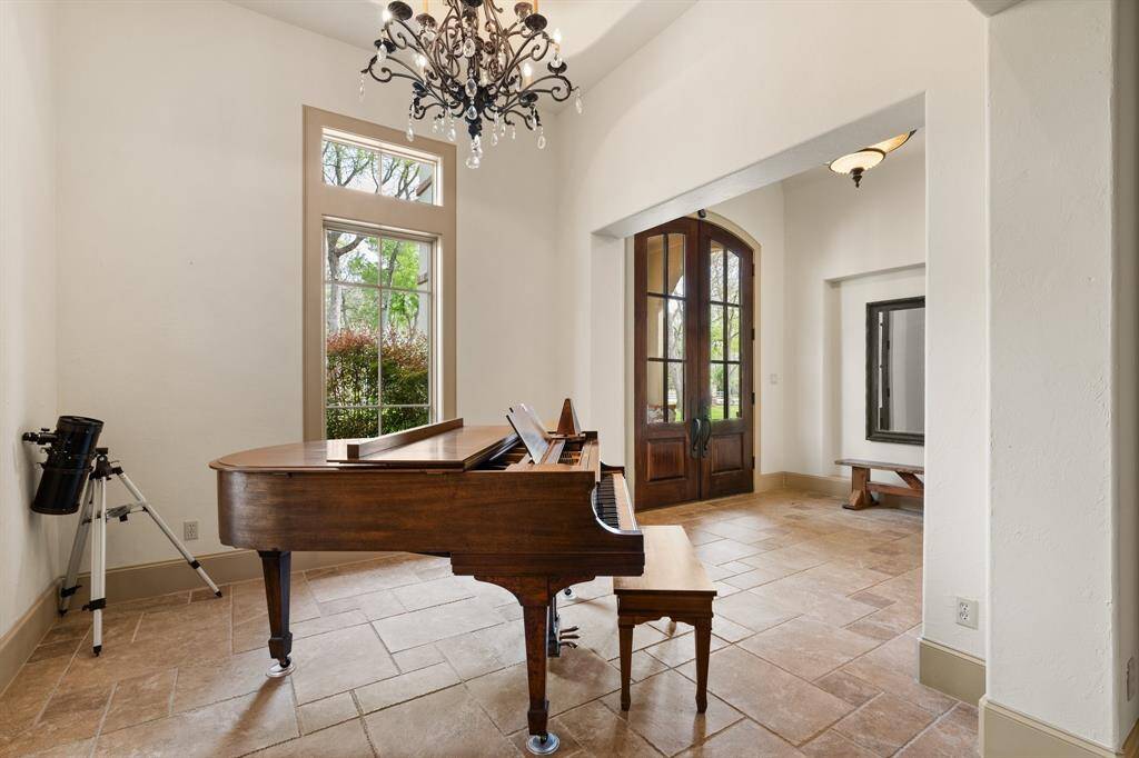 This house boasts an array of functional spaces, with the grand piano commanding attention on one side and the  dining area on the other.