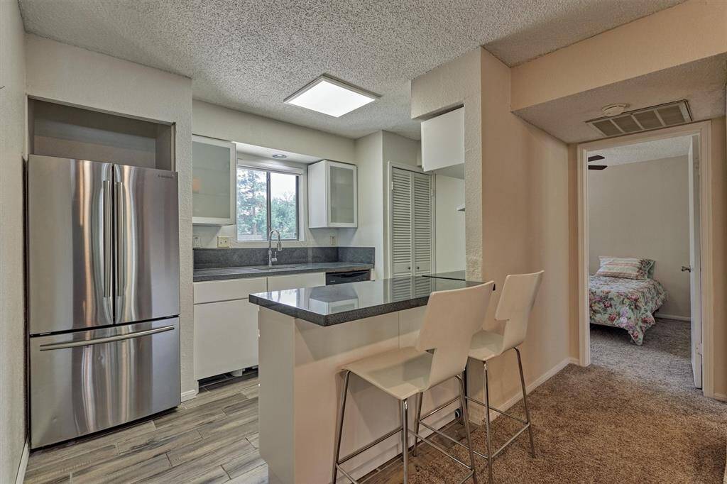 The kitchen has wood-look tile and marble countertops and backsplash.