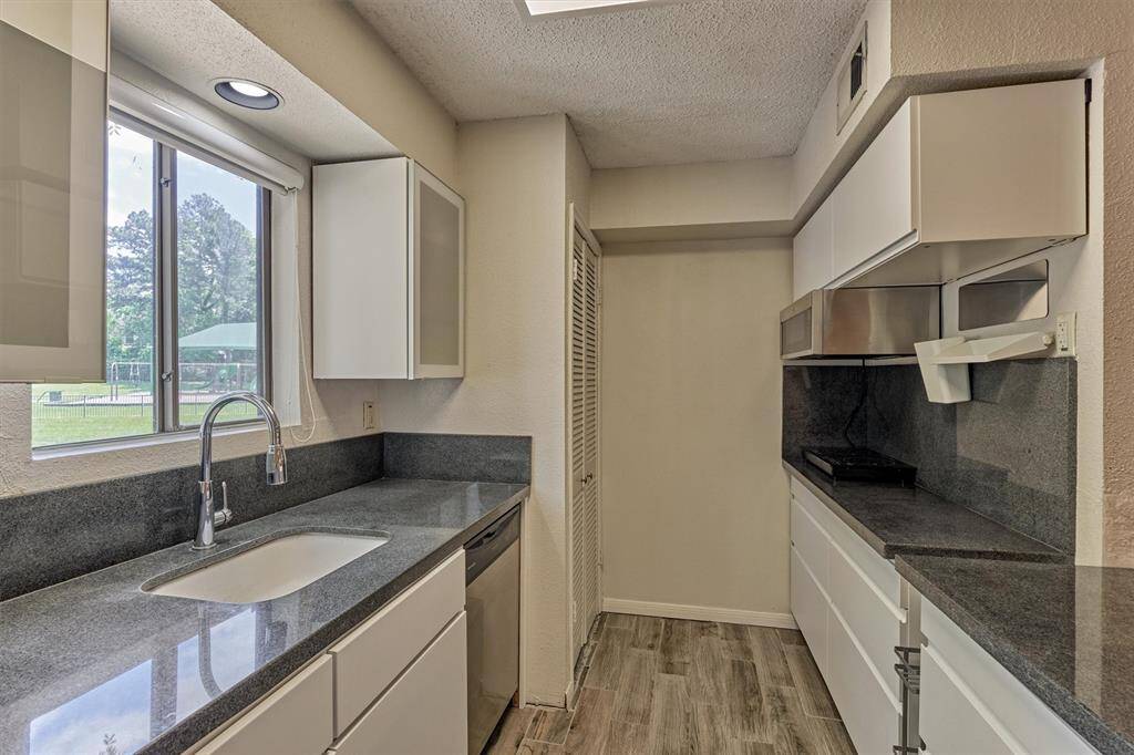 The stackable washer and dryer are in the closet to the left. The kitchen window looks out to the community park across the street.