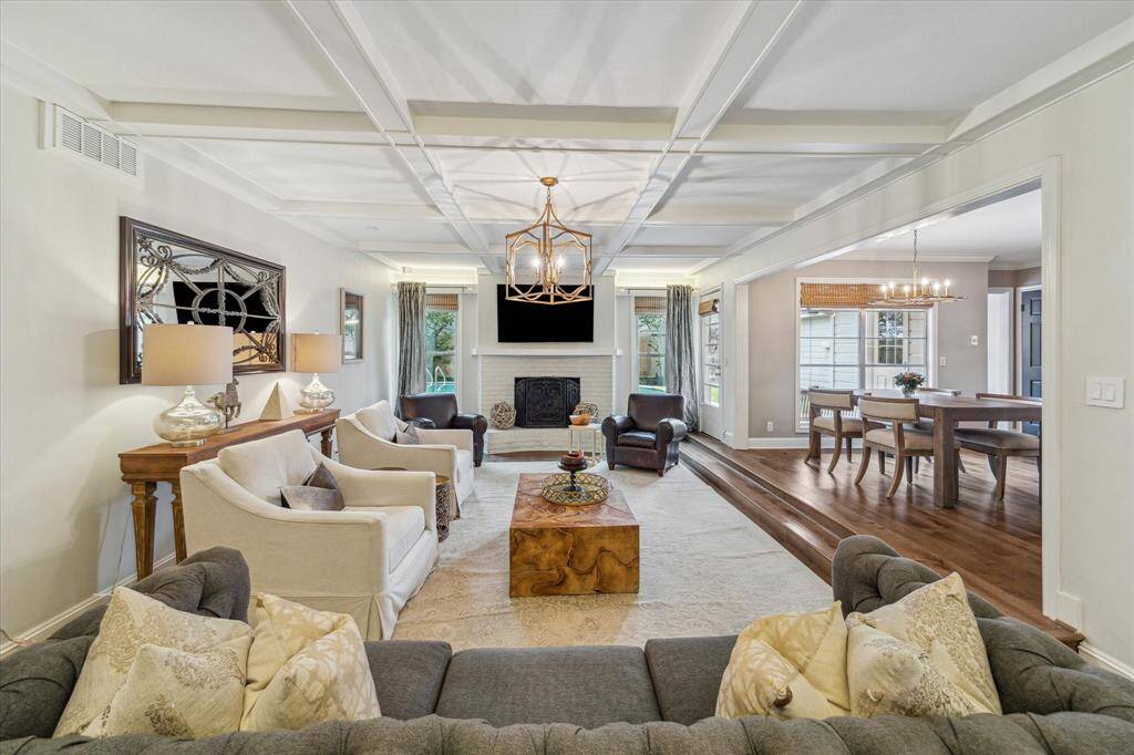 Family room with coffered ceiling anchored by a gas log fireplace