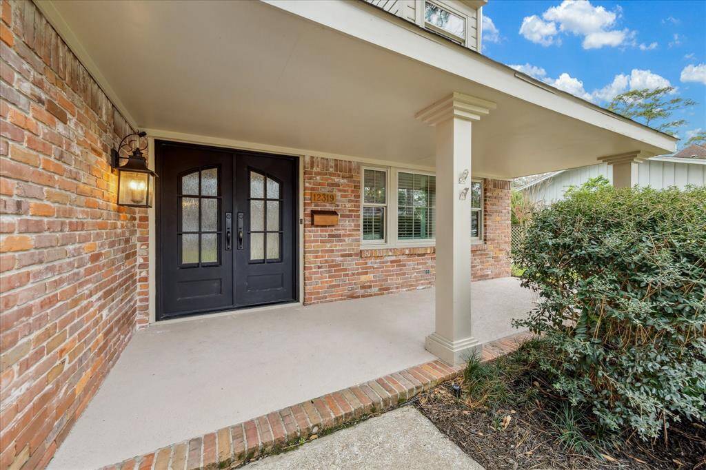 Double iron doors and a large front covered porch