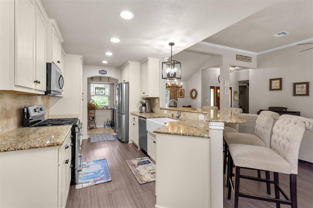 Spacious kitchen with plenty of counter space, cabinets and bright lighting.