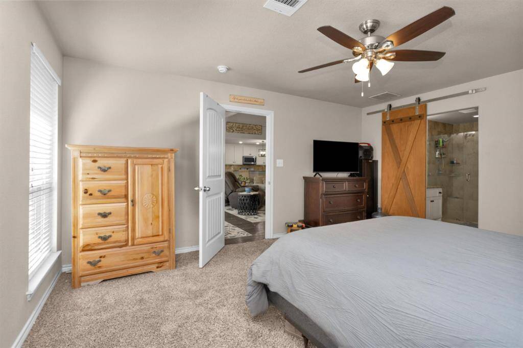 Another view of primary with barn door to primary bath. This room is located on left side of home.