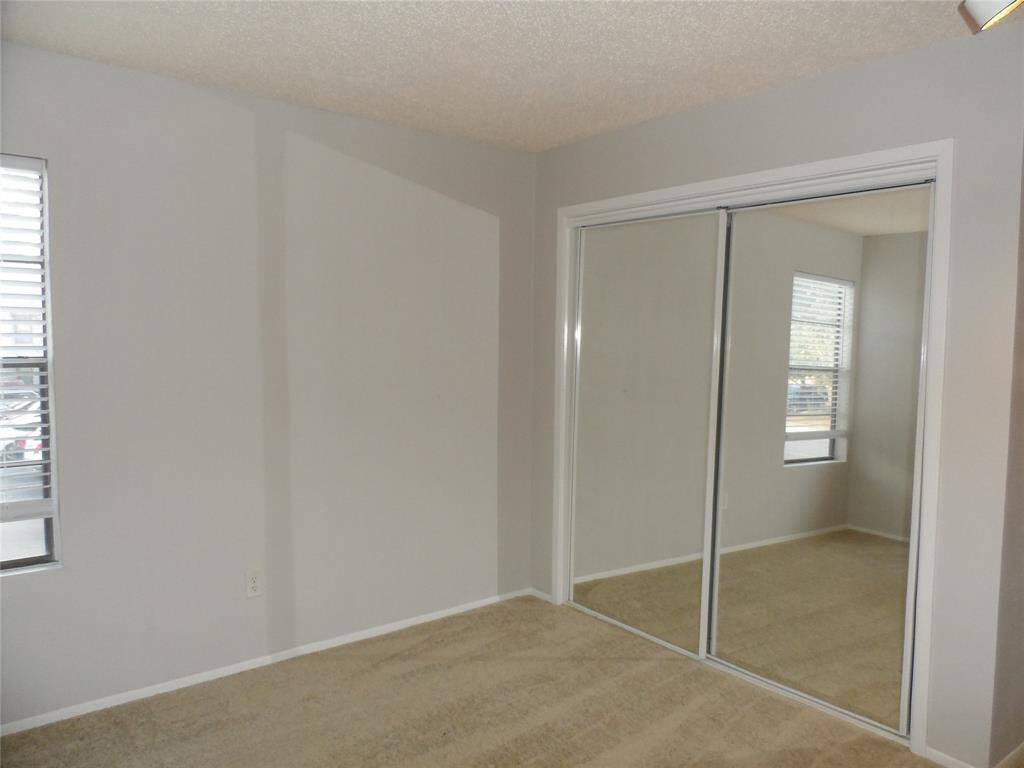 Natural light enters through a window with blinds, creating a bright and inviting space in the primary bedroom.