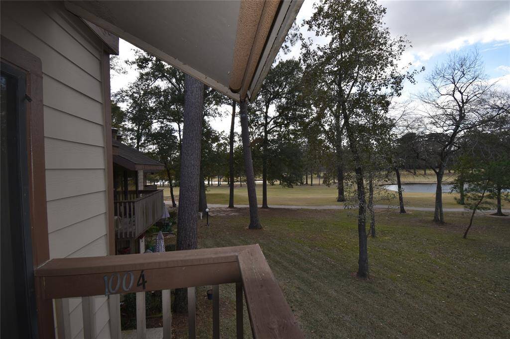 This photo showcases a scenic view from a balcony, highlighting a spacious yard with mature trees, offering a serene and natural setting.