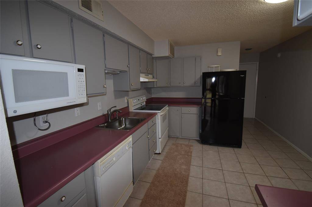 This kitchen features gray cabinets, offering ample storage and workspace for cooking.