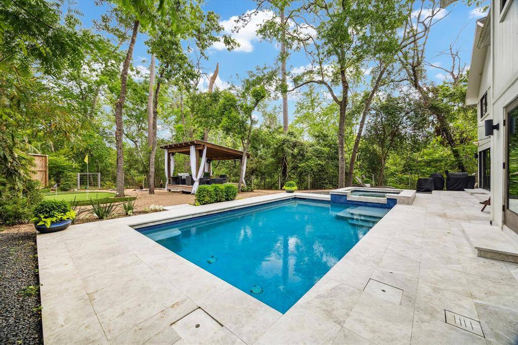 Huge back yard features pristine swimming pool, spa, putting green, and cabana.