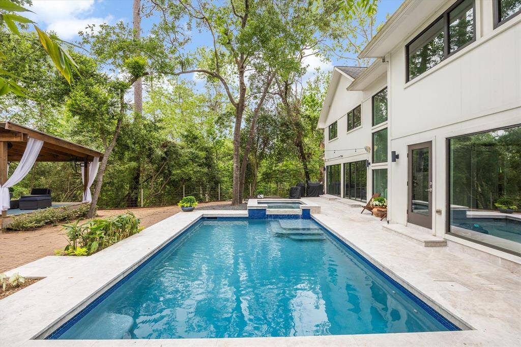 Huge back yard features pristine swimming pool, spa, putting green, and cabana.