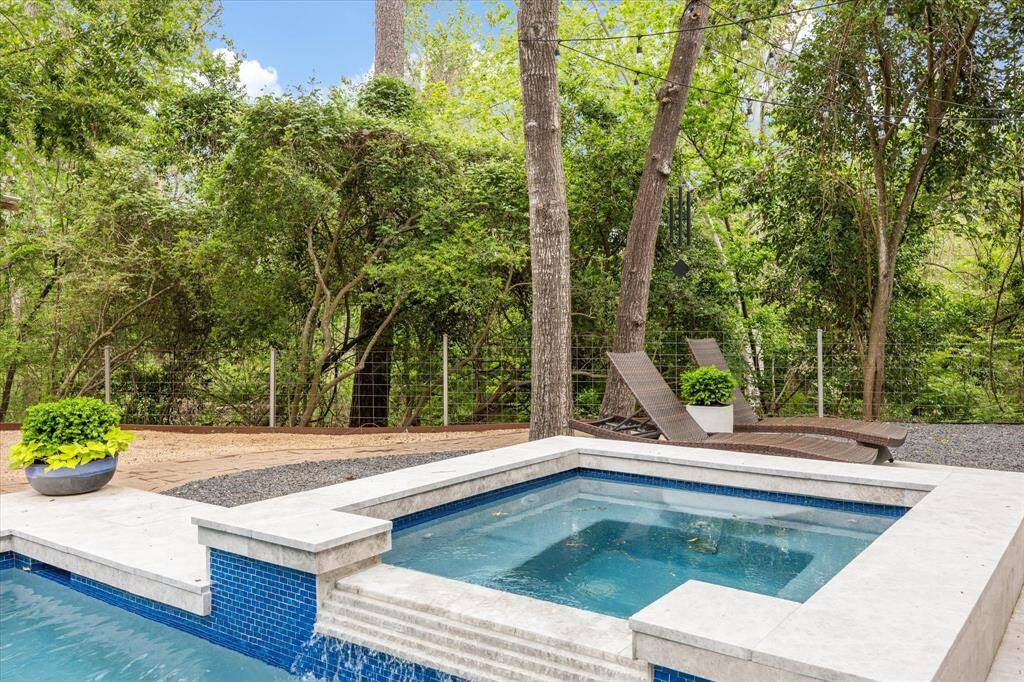 Huge back yard features pristine swimming pool, spa, putting green, and cabana.