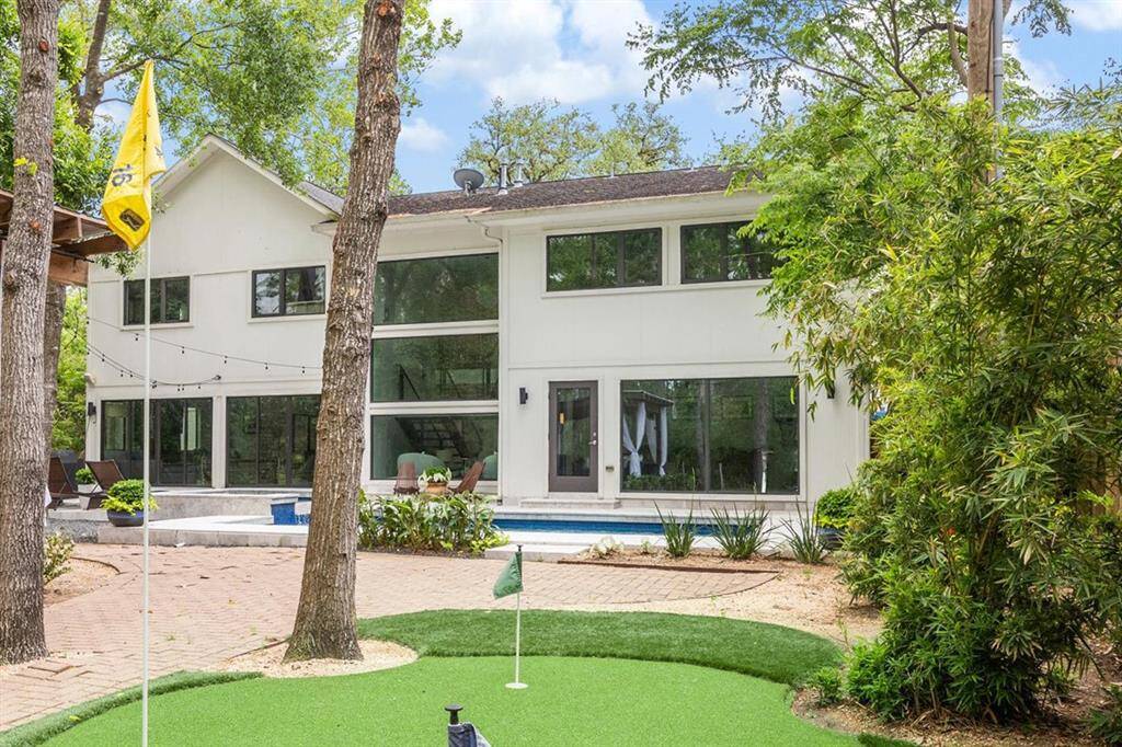 Huge back yard features pristine swimming pool, spa, putting green, and cabana.