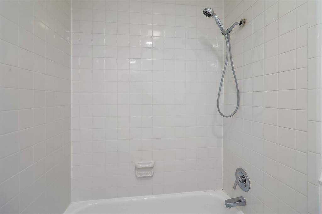 The bathroom is thoughtfully equipped with a well-designed shower or tub-shower combo.