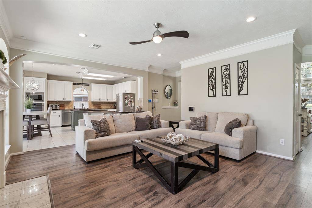 This inviting living room is designed for both comfort and connection. Soft-toned walls, rich wood-style flooring, and neutral furnishings create a warm, modern vibe. There’s plenty of space to stretch out and relax, whether you're hosting guests or enjoying a cozy night in.