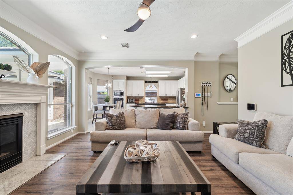 Gather, relax, and unwind in this cozy yet spacious living room. With a central fireplace, soft neutral tones, and oversized windows that bring in plenty of natural light, this space was designed for comfort and connection.