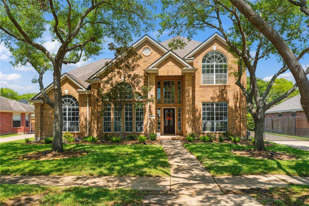 This stunning two-story brick beauty makes a grand first impression with its soaring arched windows, elegant architectural lines, and mature shade trees.