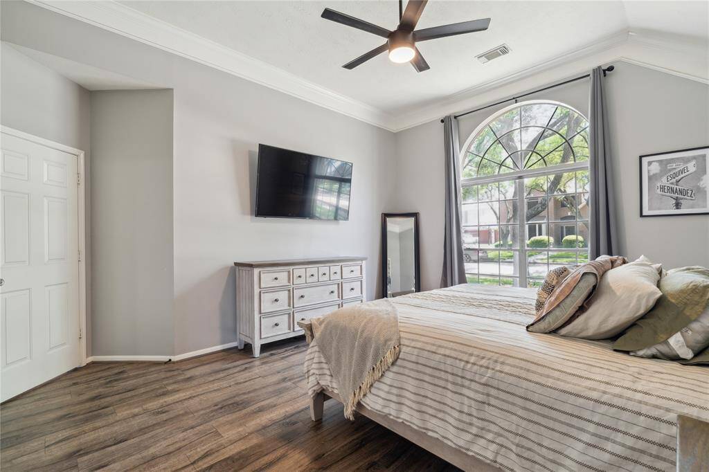 The neutral color scheme and wood-look floors provide a peaceful foundation, while the room’s size easily accommodates a king bed and large furniture.