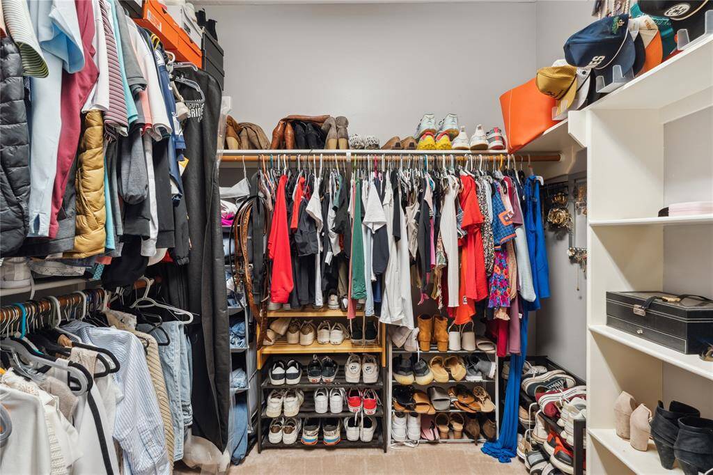 This spacious walk-in closet offers generous storage with double-tiered hanging space, built-in shelving, and custom shoe racks. Whether you need room for an extensive wardrobe, seasonal items, or accessory organization, this closet makes daily living easy and clutter-free.