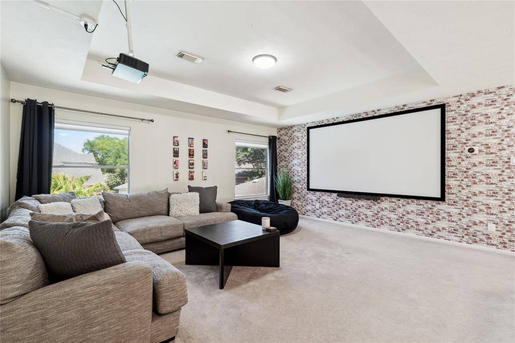 Movie nights just got an upgrade. This oversized media room is the perfect space for entertaining with a built-in projector, full-screen setup, and enough room for a large sectional. Natural light during the day, cinema vibes at night—this flex space is ready for it all.