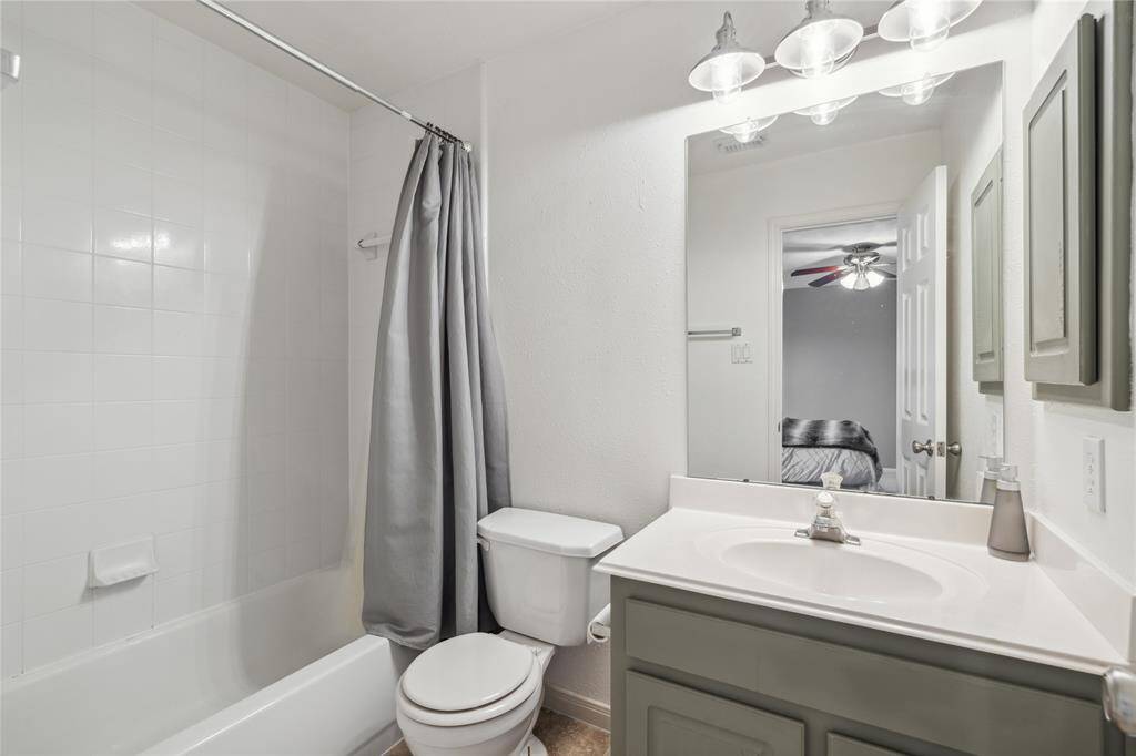 The third ensuite bathroom features a clean white tub/shower combo, updated lighting, and a soft color palette that feels fresh and modern. Ideal for guests or additional family members.