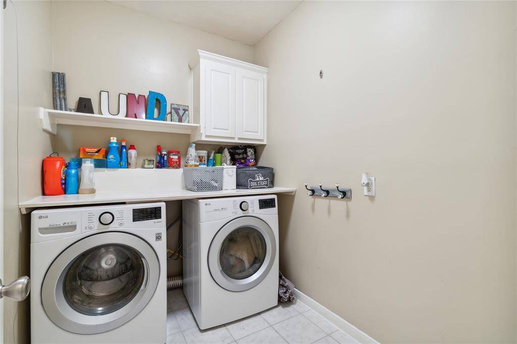 The laundry room is practical and efficient, featuring built-in cabinetry and shelf space to keep everything organized. Tucked away but easily accessible—making laundry day feel a little less like a chore.