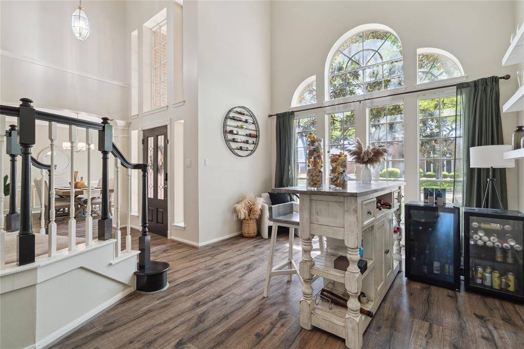 From this view, you can feel the openness of the home. Towering windows and high ceilings flood the space with light, while the bar nook seamlessly connects to the formal entry and dining room. It’s the kind of layout that makes guests feel right at home from the moment they walk in.