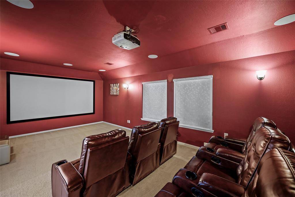 Experience ultimate movie nights with friends and family in this media room, featuring a large screen for an immersive viewing experience.