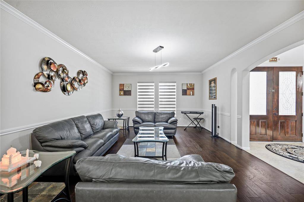 The formal living room opens up a tiled hallway with staircase.
