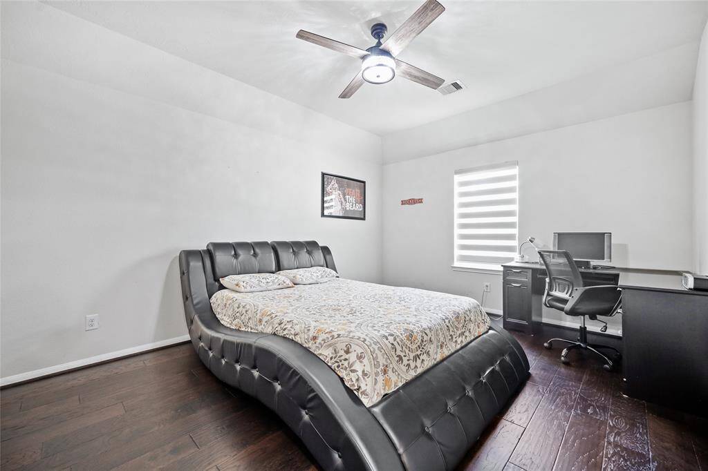 Spacious and inviting bedroom 5 with sleek flooring, modern ceiling fan, and ample natural light—perfect for rest and productivity.