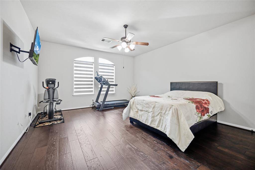 Discover Bedroom 6: a spacious retreat with elegant wood flooring, ample natural light, and space for rest and exercise. Ideal for relaxation.