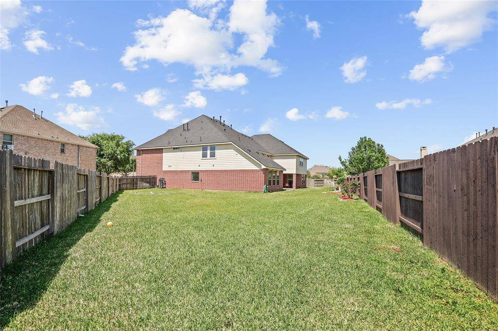 Spacious backyard with well-maintained lawn,  perfect for outdoor activities and privacy.