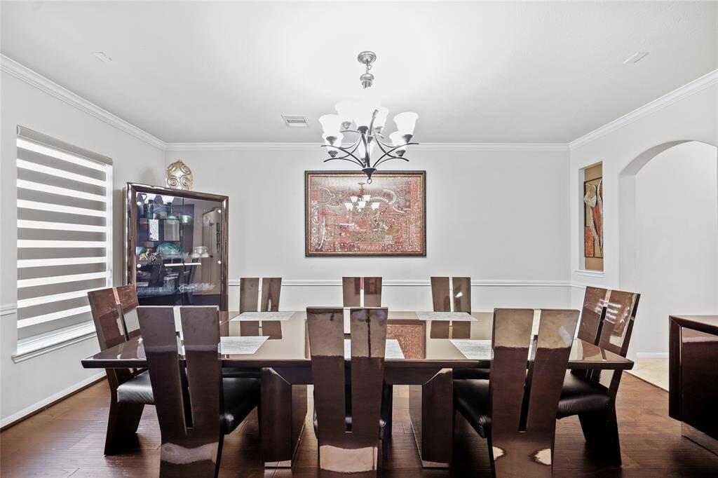 This dining room features crown molding and stylish window coverings, offering a sophisticated space for dining and entertaining.