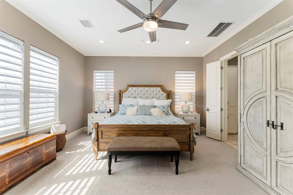 Spacious primary suite featuring abundant windows with shades and two walk-in closets.