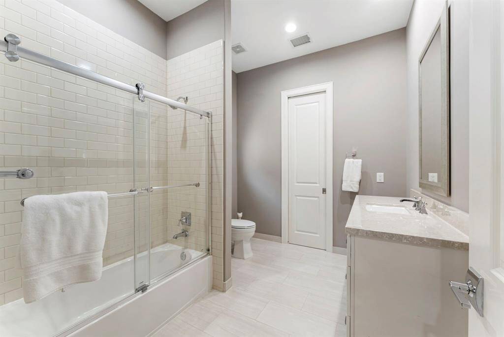 Private en-suite bathroom featuring tile flooring, a shower/tub combo, and a walk-in closet.