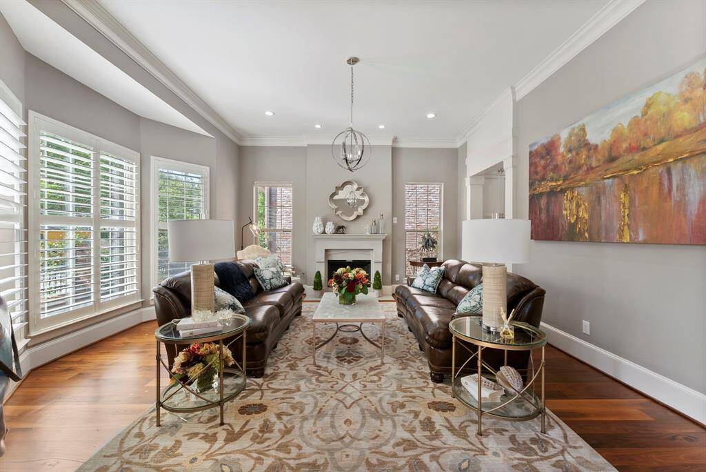 Elegant first-floor formal living with gas log fireplace, bay windows, soaring ceilings, and seamless kitchen access.