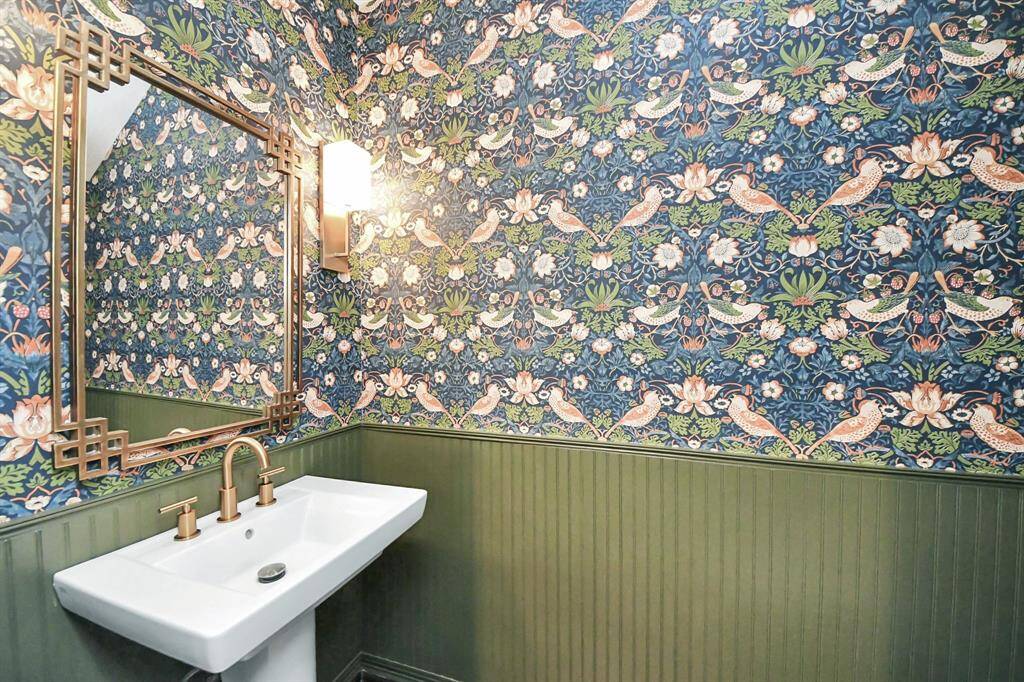 All elements in here have been updated including toilet, pedestal vanity, custom installed trim, fresh wallpaper and new brass mirror, sconces and hardware.