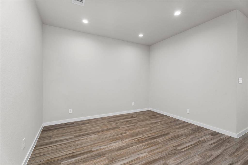 This versatile bonus room offers a blank canvas for a home office, media room, or workout space. Defined by soft neutral walls, recessed lighting, and matching luxury vinyl plank flooring, the room exudes quiet sophistication and adaptability.