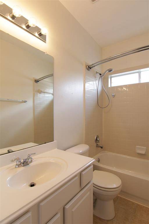hall bath with tiled tub/shower surround and pull-down shower head