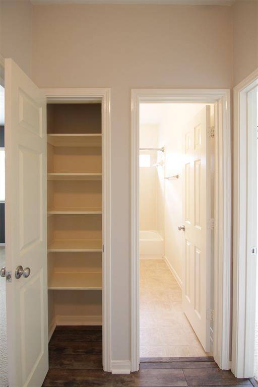 hall linen closet adjacent to hall bath between 2 secondary bedrooms
