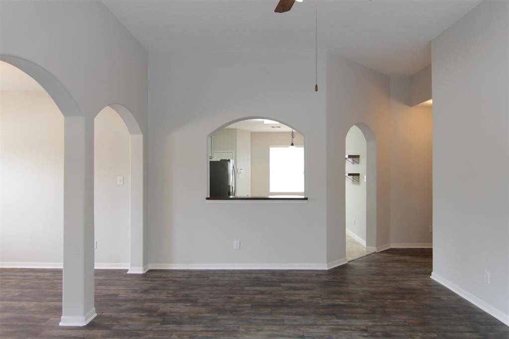 living room looking toward kitchen; gorgeous, modern, grey-tone, laminate wood flooring throughout