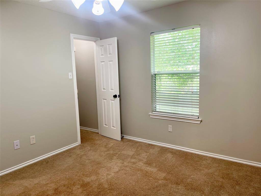 This Formal dining room features a rustic wooden sliding barn door, neutral walls, and wood-look tile flooring, offering a cozy and modern aesthetic.