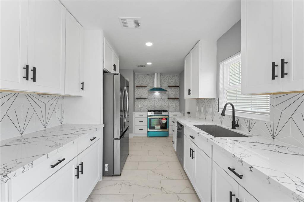 A chef's dream with style to match, great counter space, striking black hardware, and a statement tile backsplash set the tone.