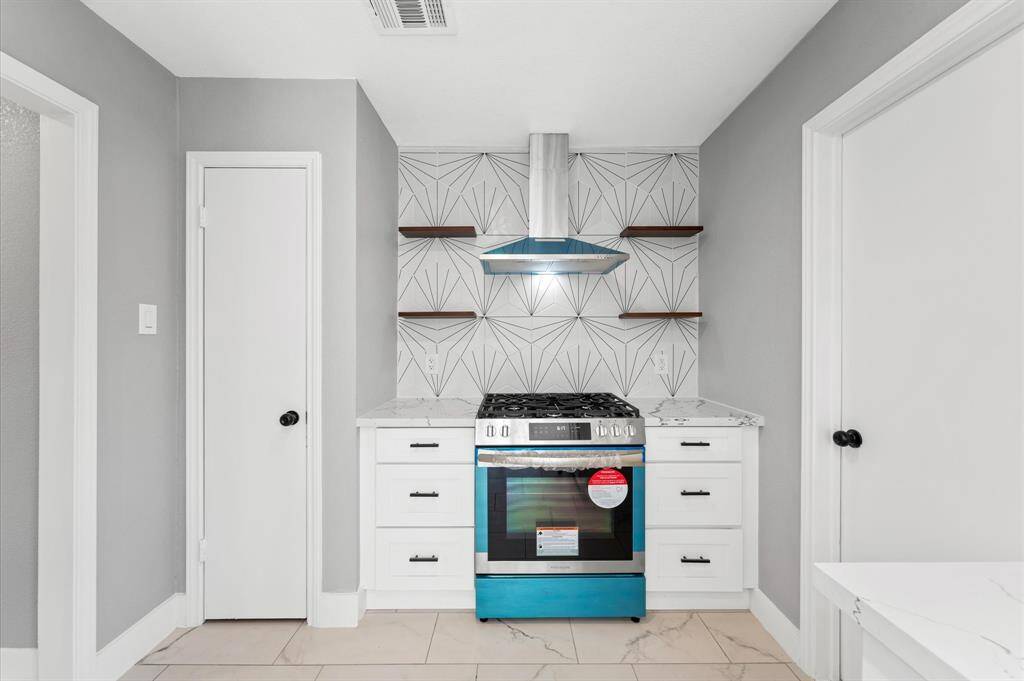 Contemporary elegance meets everyday function in this thoughtfully designed kitchen with open shelving and high-end finishes