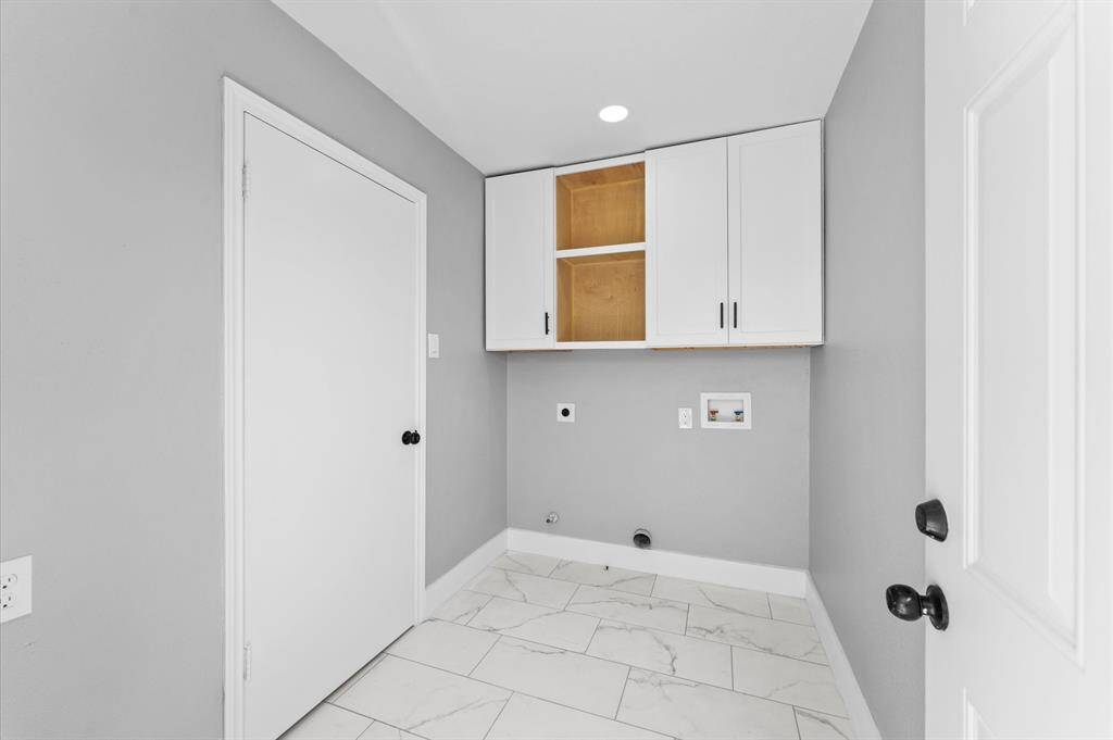 SPACIOUS laundry room with excellent storage and access to backyard.