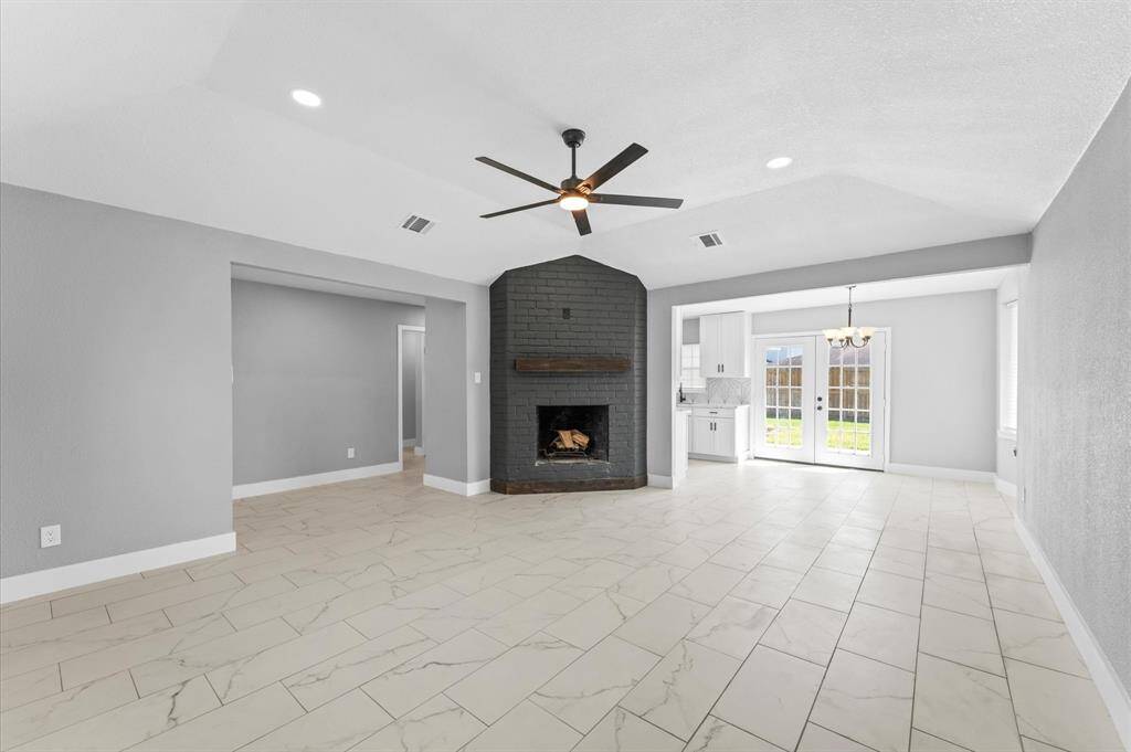Striking fireplace adds a bold touch to this light-filled space with a view to the dining room