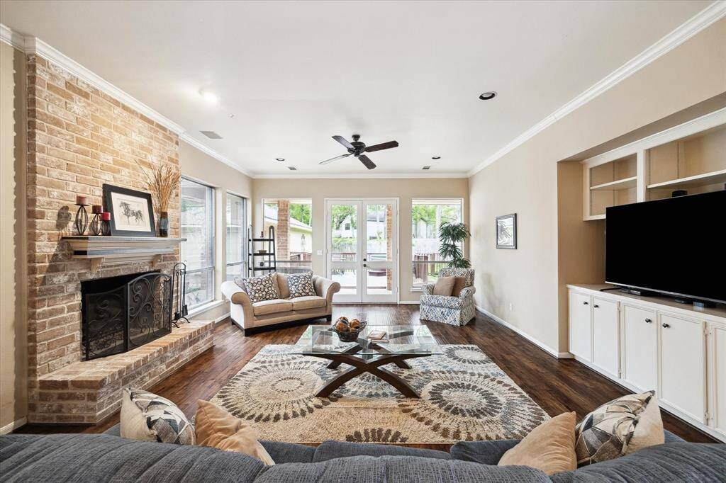 Living room with fireplace, wood flooring, high ceilings, and built-ins.