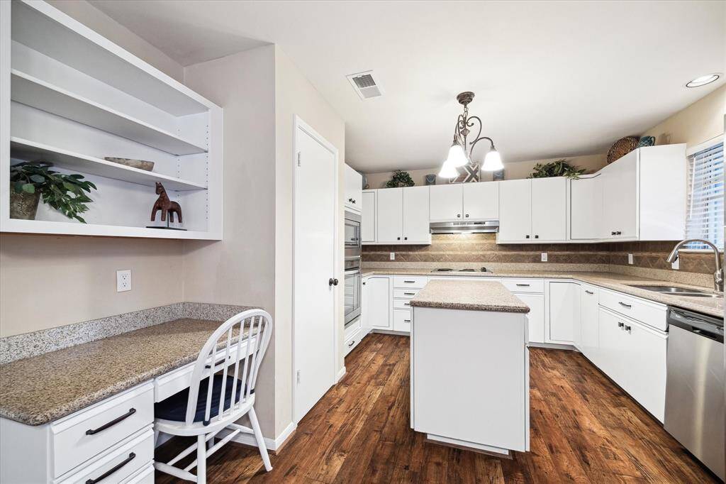 Kitchen with white cabinetry, granite counters, and plenty of storage.