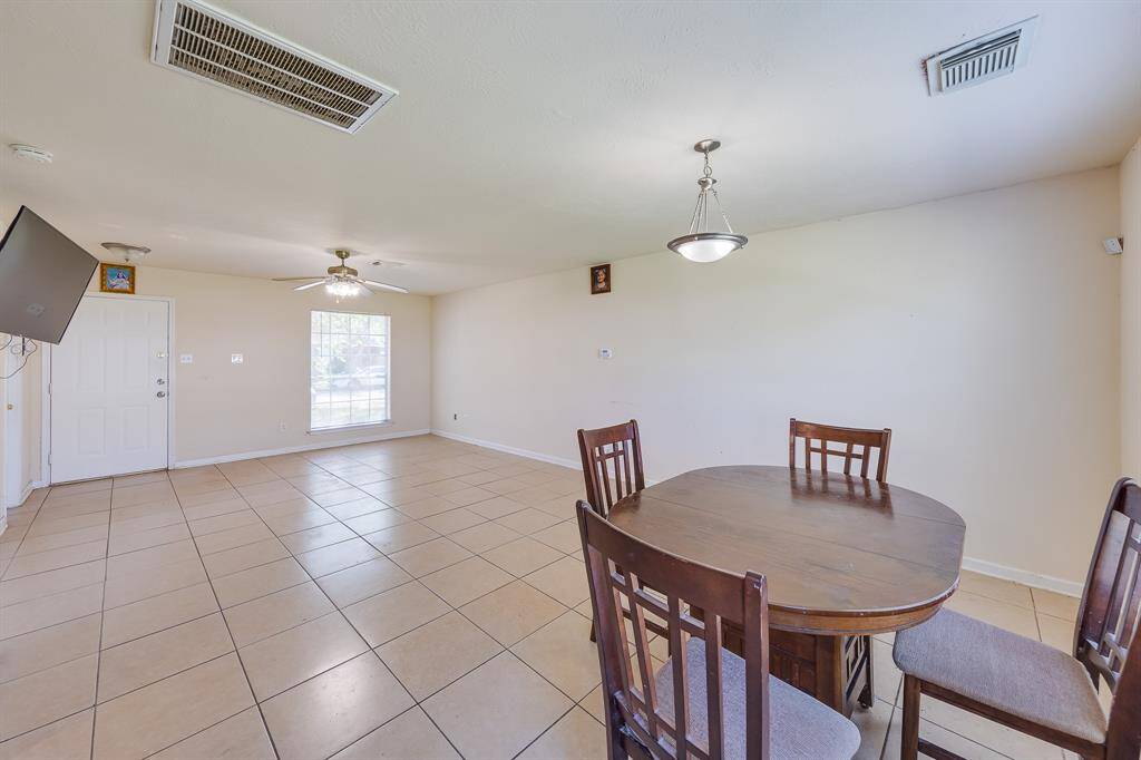 Another view of the bright living-dining area, featuring natural light and easy-to-maintain ceramic tile floors.