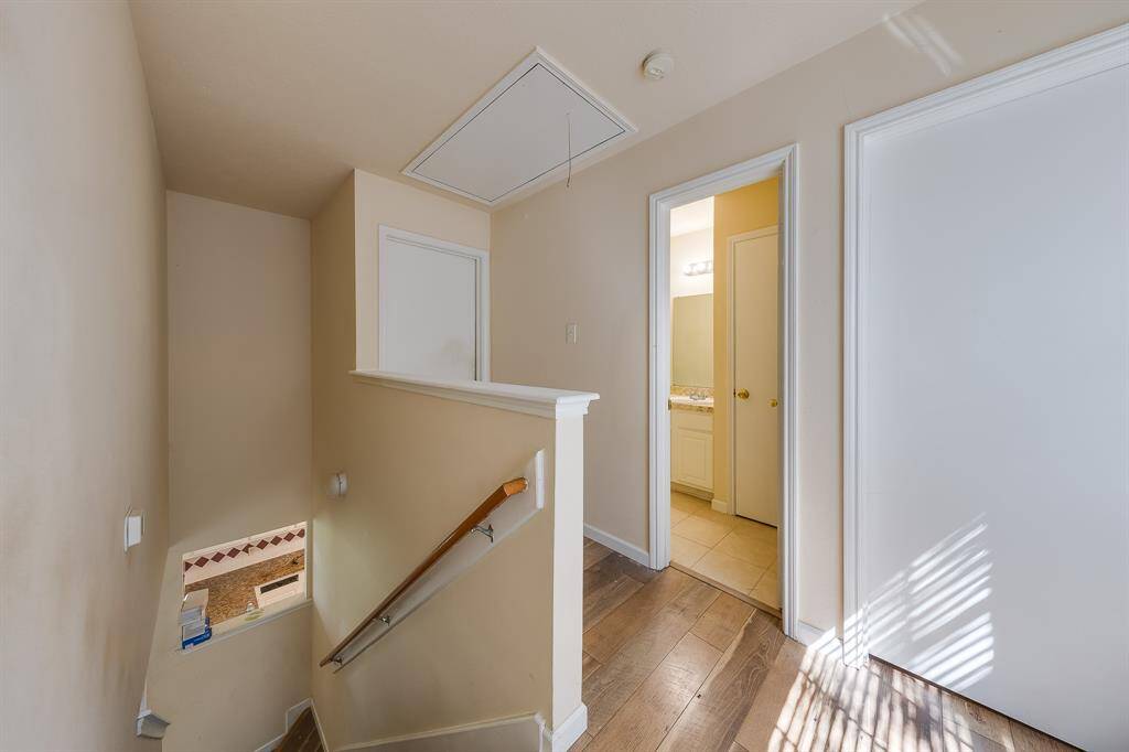 A glimpse of the upstairs hallway leads to the bedrooms, including the spacious master suite and a shared bathroom, perfectly designed for family living and privacy.