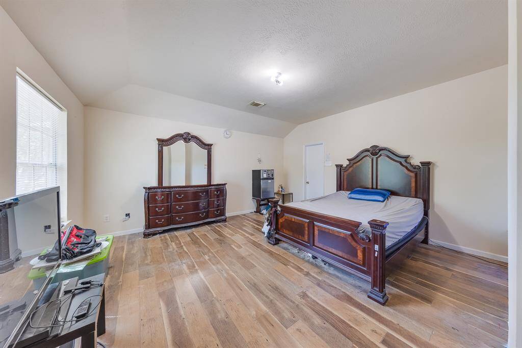 Master bedroom with sleek laminate flooring, offering a cozy retreat and direct access to the private bathroom for ultimate convenience.