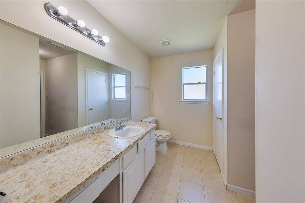 Stylish bathroom featuring a single sink and vanity space, perfect for multitasking, whether washing up or applying makeup without interrupting each other.