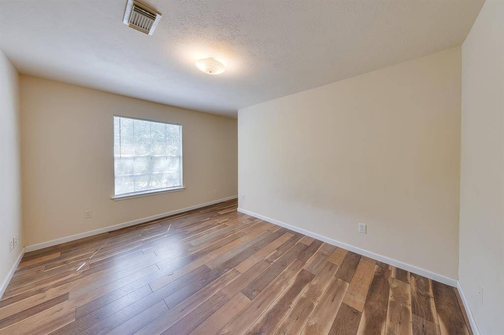 This second bedroom with laminate wood-like flooring, perfect for someone excited to create their own unique decor and style.